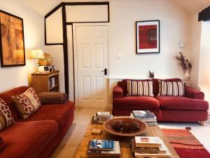 a living room with two red couches and a coffee table at The Blue Cow in Fenstanton