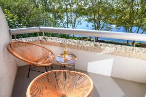 2 sillas y una mesa en el balcón en The Luxe Lake - Duke Housing, en Créteil