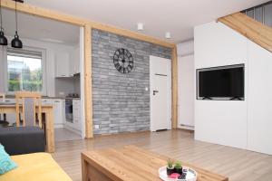 a living room and kitchen with a brick wall at Bolek Lolek Domki Apartamenty in Wilkasy