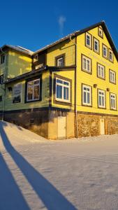 una casa de ladrillo amarillo con una calle delante de ella en Hotel Schöne Aussicht, en Masserberg