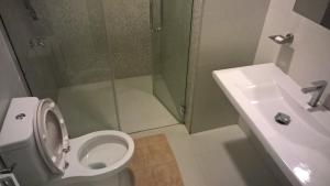 a bathroom with a shower and a toilet and a sink at AMARASINGHE GUEST HOUSE in Haputale