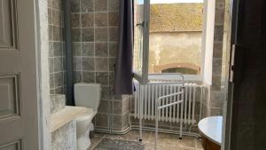 uma casa de banho com um WC e uma janela em Grand corps de ferme à la rue Messire Etienne 89113 Neuilly Valravillon em Neuilly