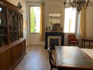 a dining room with a table and a fireplace at Grand corps de ferme à la rue Messire Etienne 89113 Neuilly Valravillon in Neuilly
