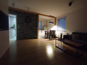 un soggiorno con un divano e un tavolo di Bolek Lolek Domki Apartamenty a Wilkasy