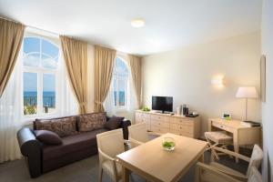 salon z kanapą i stołem w obiekcie Apartments Belvedere - Liburnia w mieście Lovran