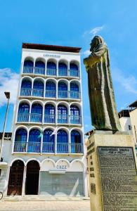 a large building with a statue in front of it at Hotel Lenheiros in São João del Rei