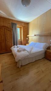 a bedroom with a large white bed in a room at Hotel Ristorante Genzianella in Madonna di Campiglio