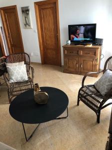 托羅克斯的住宿－Torrox Pueblo Hidden Gem, 2 Bed Apartment，客厅配有两把椅子、一张桌子和一台电视