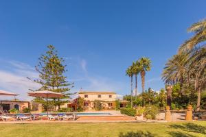 een huis met een zwembad en palmbomen bij Finca Sitjoles in Campos