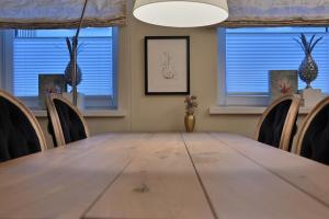 einen Tisch und Stühle in einem Zimmer mit Fenstern in der Unterkunft Ferienwohnung PRACHTSTÜCK in Flensburg