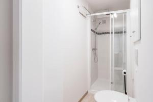 a white bathroom with a shower and a toilet at Comfortabele, moderne studio zeedijk De Panne in De Panne