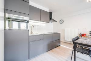 a kitchen with stainless steel appliances and a table at Comfortabele, moderne studio zeedijk De Panne in De Panne