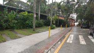 an empty street with trees and a parking lot at Calumar Guest House in Ubatuba