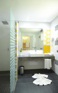 une salle de bain avec un lavabo et un grand miroir dans l'établissement One Resort Aqua Park, à Monastir