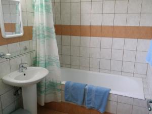 a bathroom with a sink and a bath tub and a sink at Kkaras Hotel in Ayia Napa