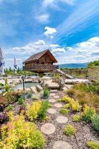 un bâtiment avec un jardin fleuri devant lui dans l'établissement Къмпинг Алианс, à Plovdiv