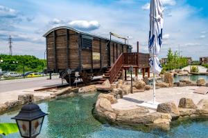 a train car sitting on top of a body of water at Къмпинг Алианс in Plovdiv