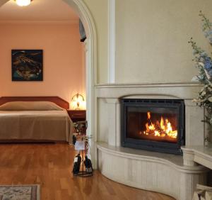 a fireplace in a bedroom with a bed at National Palace Spa & Wellness Hotel in Sliven