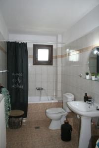 een badkamer met een toilet, een wastafel en een bad bij Moschoula Villa - Apartment 1 in Limenas