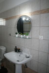 een badkamer met een wastafel, een spiegel en een toilet bij Moschoula Villa - Apartment 1 in Limenas