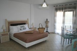 a bedroom with a bed and a table and chairs at Moschoula Villa - Apartment 1 in Limenas