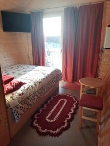 1 dormitorio con cama, mesa y ventana en Metsjärve mini puhkemaja, en Põlva