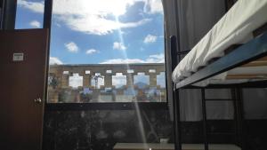 ventana en un dormitorio con vistas a un edificio en Albergue La Estación, en Cehegín