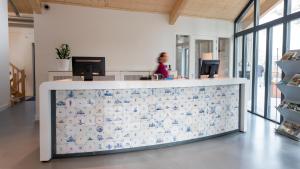 a woman standing at a counter in an office at Vakantiepark Delftse Hout in Delft