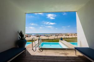 a pool with a view of the beach from a house at Nachsholim Beach Hotel in Nahsholim