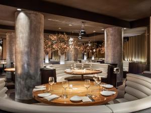 una sala da pranzo con tavoli, sedie e lampadari di ME Milan Il Duca a Milano