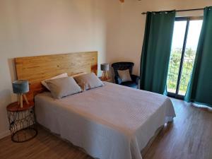 a bedroom with a large bed with a wooden headboard at Ponta do Sol Private Apartment Sea View in Ponta do Sol