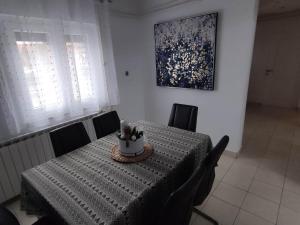 ein Esszimmer mit einem Tisch mit Stühlen und einem Gemälde in der Unterkunft Apartment Roki in Zagreb