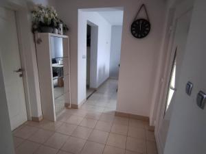 a hallway with a clock on a white wall at Apartment Roki in Zagreb