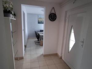 a hallway with a clock on the wall and a table at Apartment Roki in Zagreb