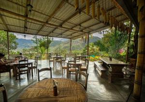 a restaurant with tables and chairs and mountains in the background at Fundo San Jose Parque Ecológico & Lodge Hotel Asociado Casa Andina in La Merced