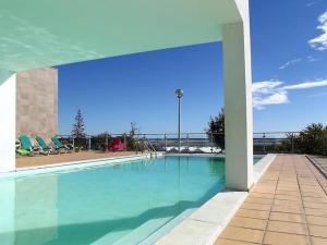 a large swimming pool with blue water and chairs at Fuseta Apartments - Bela Vista & Vista Mar - Penthouses in Fuzeta