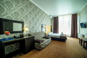 ゲレンジークにあるБутик-отель Астерияのソファとベッドルームが備わるホテルルームです。