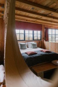 1 dormitorio con 1 cama con hamaca en La cabane du potager - Ferme de Linciaux en Ciney