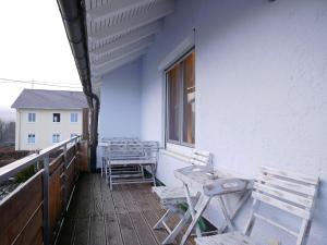 una fila de sillas y mesas en un balcón en Ferienwohnung Kußmaul, en Alpirsbach