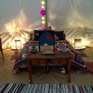 een bed met een tafel in een tent bij Finca Fahala in Cártama