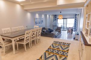 a dining room and living room with a table and chairs at Miramar Boutique Hotel in Alexandria