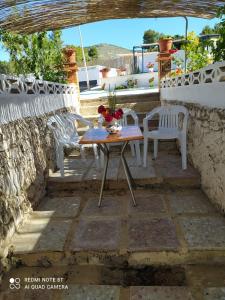 a patio with a table and chairs on a stone floor at Habitaciones en casa rural particular La Casita in Ibi