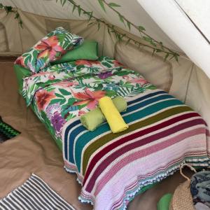 Cama en tienda de campaña con 2 almohadas y manta en Finca Fahala en Cártama