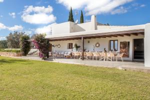 ein weißes Haus mit Rasen davor in der Unterkunft Can Skye in Sant Carles de Peralta