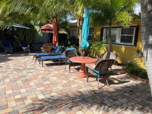 un patio con sillas, mesas y sombrillas en Atlantic Shores Vacation Villas, en Palm Beach Shores