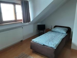 a small bedroom with a bed and a window at Račínská hospůdka in Velká Losenice