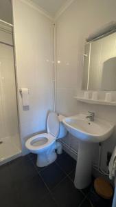 a white bathroom with a toilet and a sink at GOOD NIGHT HÔTEL By L'excess in Vierzon +33 photos