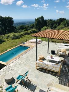 a pool with chairs and a gazebo next to at Villa Poggio in Santa-Maria-Poggio