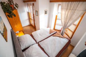 um pequeno quarto com uma cama e uma janela em Rekreačný Dom Shalom em Smrečany