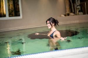 a woman swimming in a swimming pool at Hotel Kristall in Falzes
